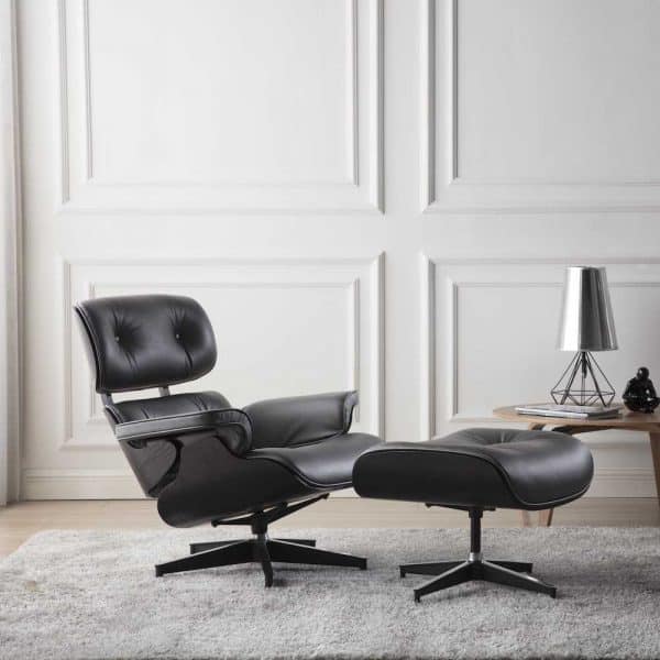 fauteuil lounge eames et ottoman eams design en cuir noir et bois de frêne noir avec une base en alu poli chromé dans une chambre