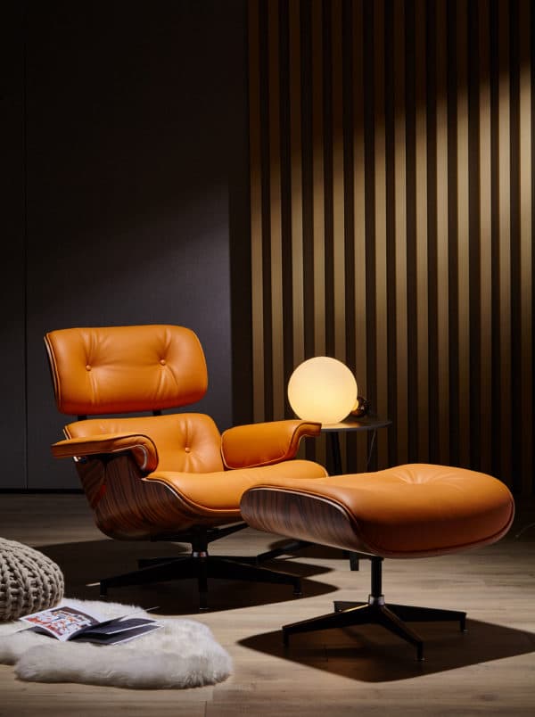copie fauteuil charles eames avec ottoman cuir italien orange bois de palissandre base alu noir dans un salon lounge