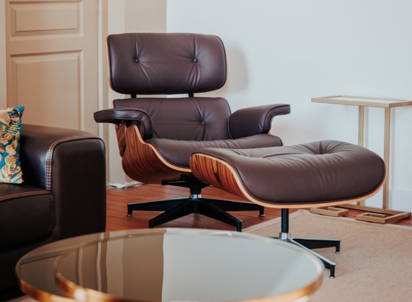 replica fauteuil charles eames avec ottoman cuir aniline marron bois palissandre dans un salon